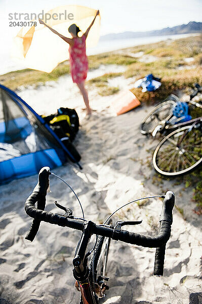 Cyclist breaking camp on Playa Ines  Baja  Mexico