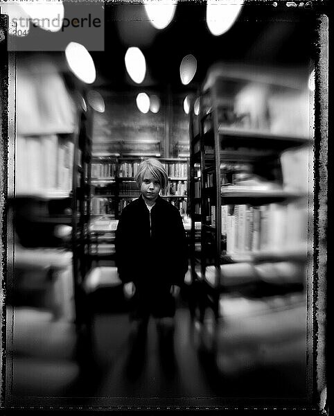 Black & White  Selective focus portrait of a young boy in a bookstore