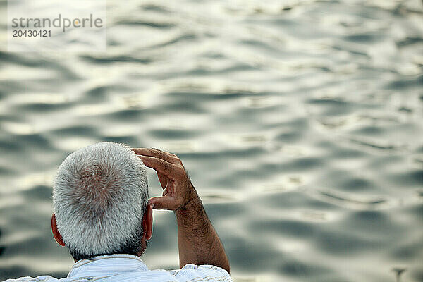 A man watches ripples of water move in one of the fountains of The World War II Memorial in Washington DC.