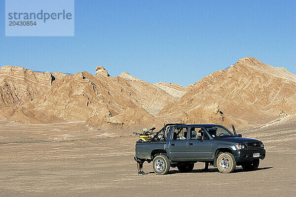 A truck carrying mountain bikes is parked in the dirt in Valle de la Luna  Chile. Valle de la Luna or Valley of the Moon is a po