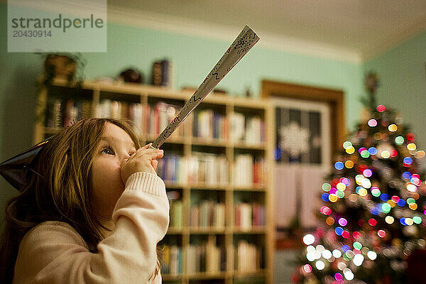 Girl blowing party horn during Christmas