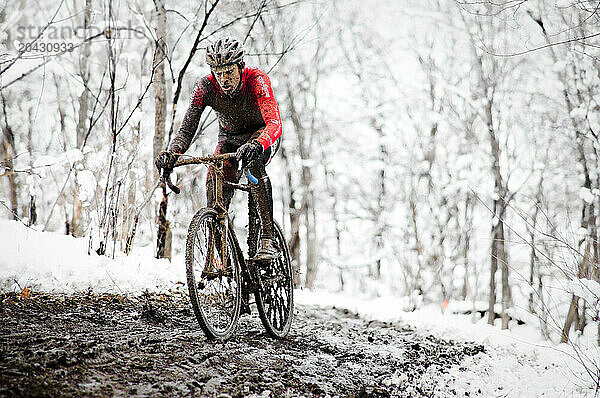 A cyclists races in the mud and snow at a Cyclocross race in Boulder  CO.