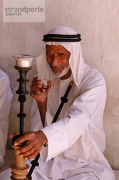 Man smoking a hookah pipe  Dubai  United Arab Emirates.