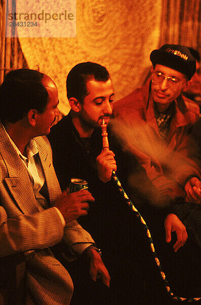 A group of men enjoy a smoke  Dubai  United Arab Emirates.