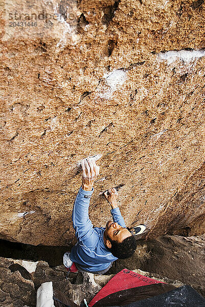 A Young African American man boulders in Hueco Tanks State Park near El Paso  Texas.