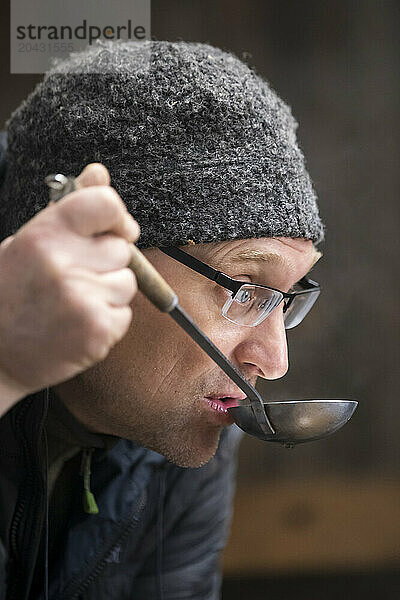 Man trying maple syrup  Littleâ€ Suamico  Wisconsin  USA