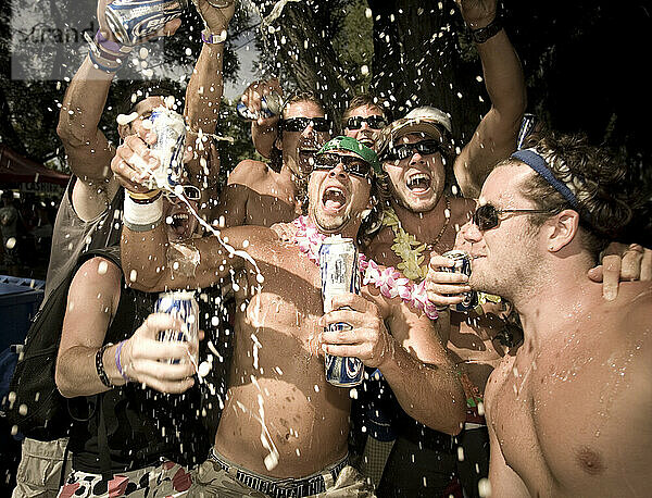 Male adults spraying beer at a party in Toronto  Ontario.