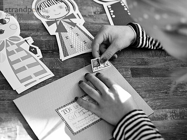 young girl puts stamp on letter