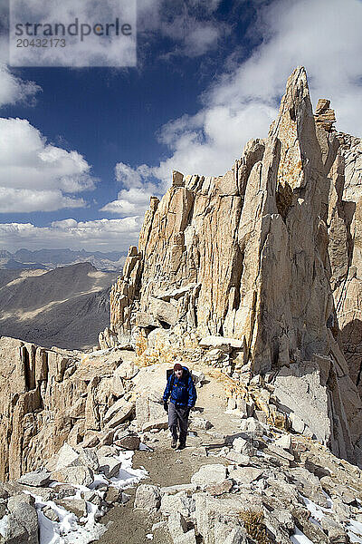 A man hikes through beautiful rock formations near the summit of Mt. Whitney.