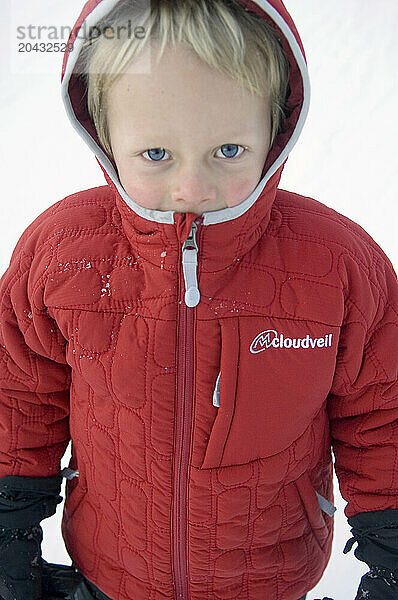 A young boy with a warm red Winter jacket in Jackson Hole  Wyoming.