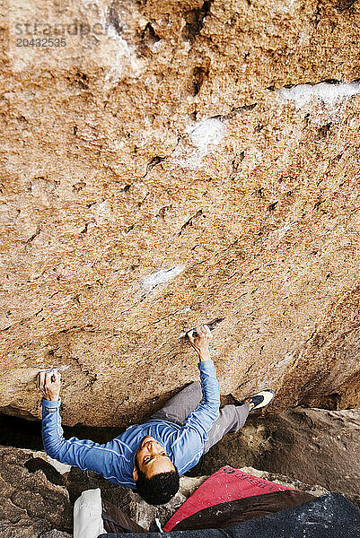 A Young African American man boulders in Hueco Tanks State Park near El Paso  Texas.