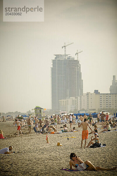 people tanning and swimming in the Atlantic Ocean on South Beach  Miami  Florida.