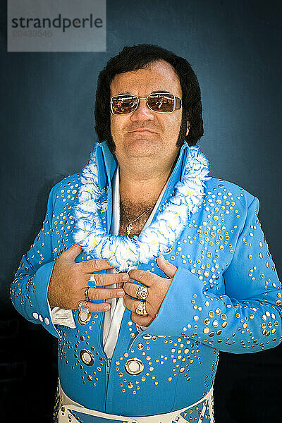 Elvis impersonator in a blue costume backstage before a performance.