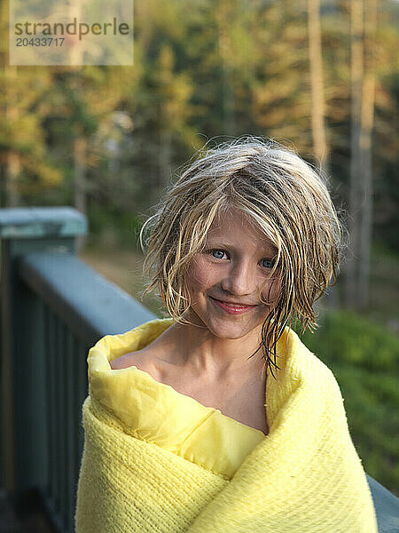 girl  wrapped in a blanket  smiles for the camera