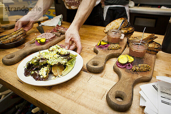 Hands preparing plates and cutting boards.