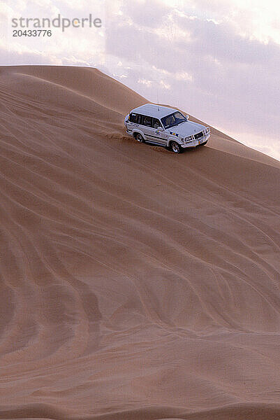 Dune Driving Land Cruisers take the desert sand at high speed. Dubai Desert.