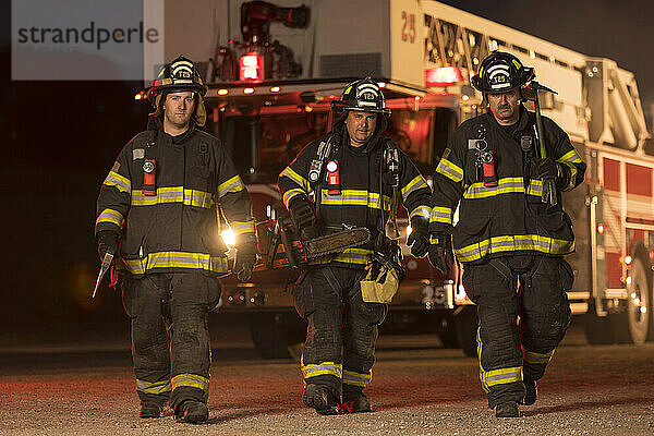 Three firefighters and fire engine behind  New Holstein  Wisconsin  USA