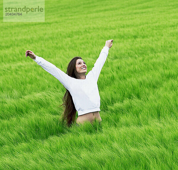 A young woman stretches in a field  Berg  Switzerland.