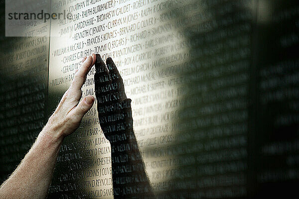 People touch and point at names on the Vietnam Veterans Memorial Wall in Washington  DC.