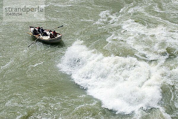 A boatman rows his dory clear of a big wave on the Colorado River in Grand Canyon National Park  Arizona.