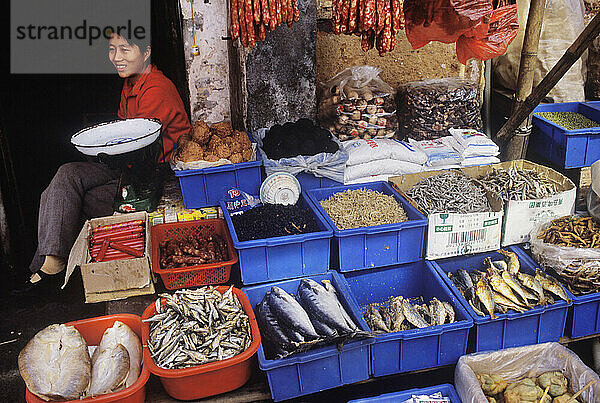 A young woman tending her stall at a market in Aozai  China.