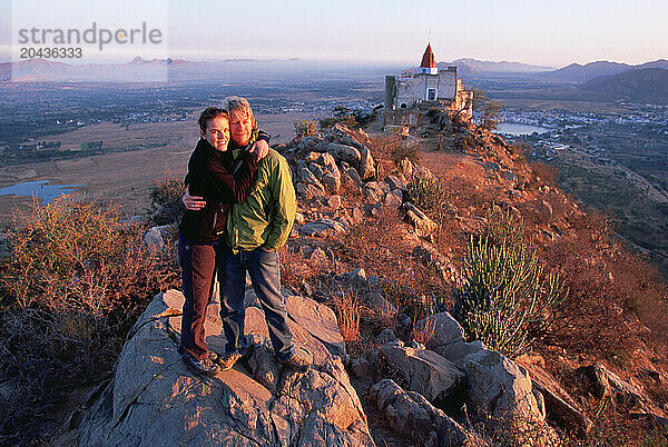 Two travellers enjoying a sunrise at the top of Ratnagiri Hill.