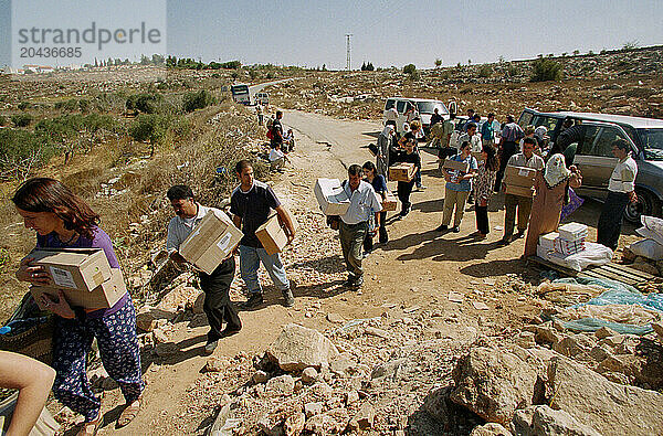 Volunteers carry medicine across roadblock