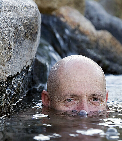 A man blows bubbles while he soaks in the hot springs outside the town of Bishop  Ca.