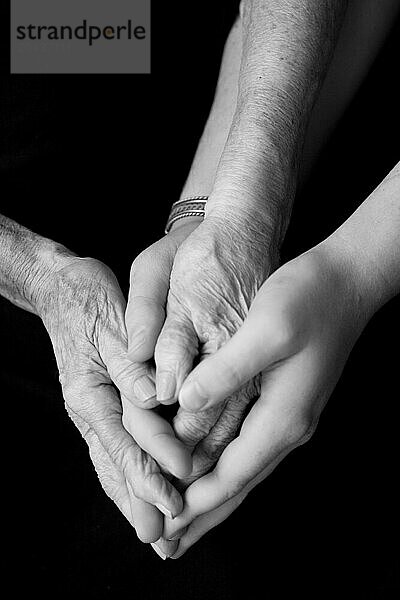 Hands of an older woman and a young man together with love and comfort.