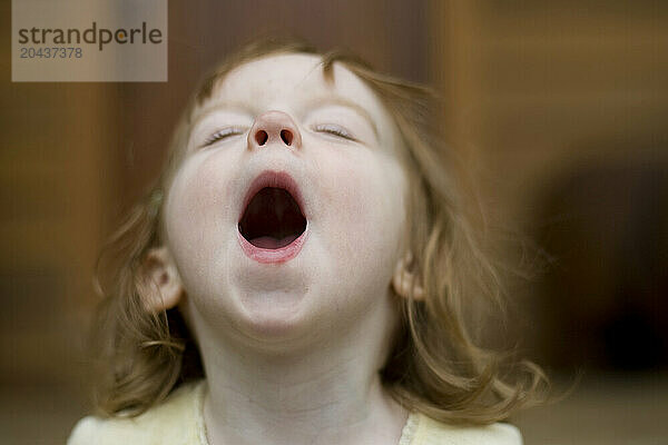 An toddler lets out a happy yell.