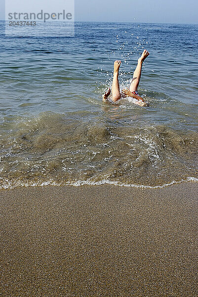 boy plays in ocean