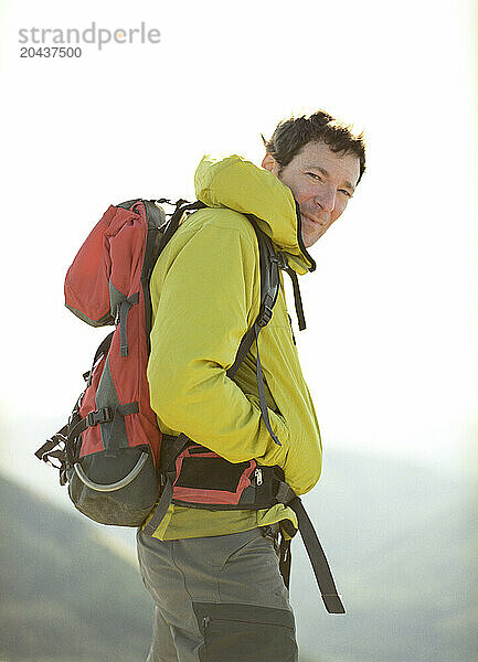 A portrait of a middle aged male hiker in a green jacket