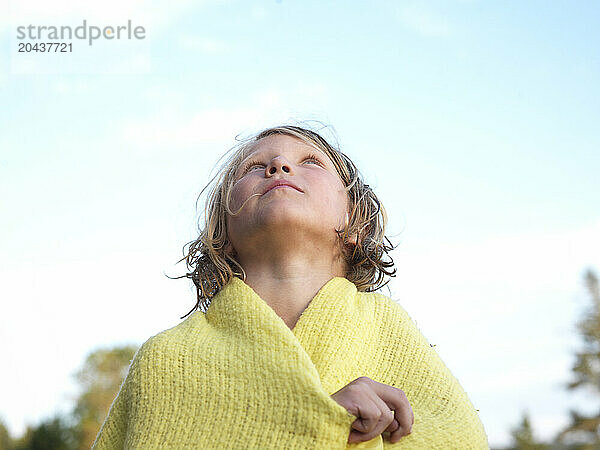 girl  wrapped in a blanket  looks up to the sky