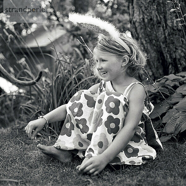 girl sitting in grass with bunny ears