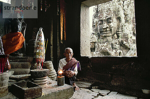 A Buddhist nun stares into the camera in Cambodia's Angkor complex.