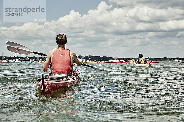 White clouds over large group of people kayaking  Portland  Maine  USA