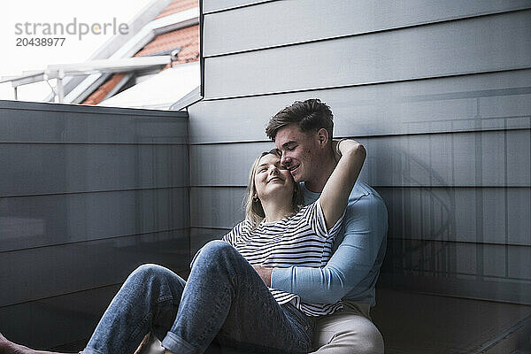 Loving couple leaning on wall on balcony