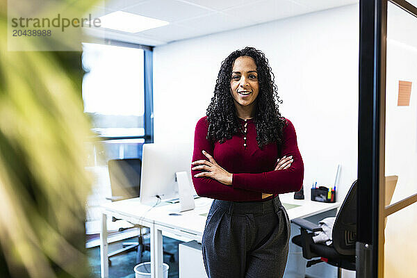 Smiling businesswoman standing with arms crossed