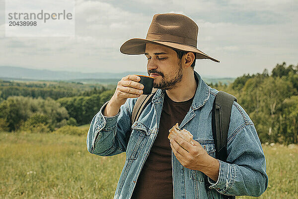 Man with eyes closed holding cup of tea and enjoying vacation