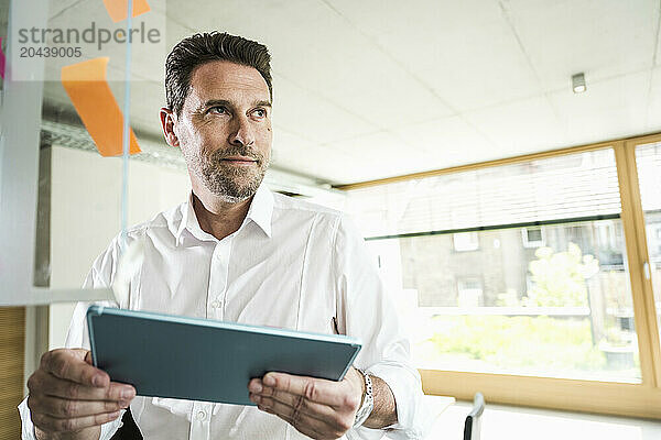 Mature businessman with tablet PC at office