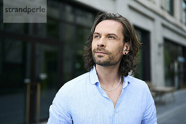 Handsome mature man with stubble wearing blue shirt