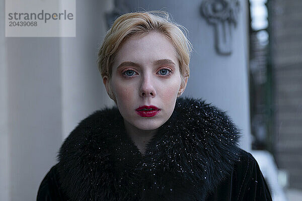 Blond woman wearing black fur coat