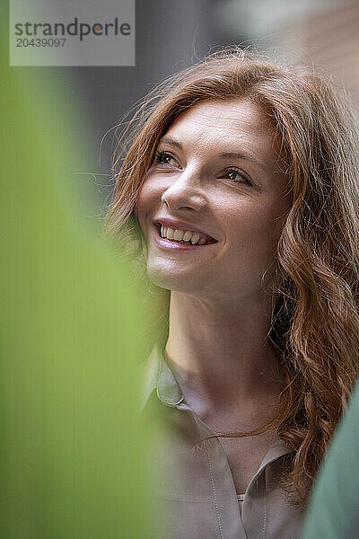 Smiling beautiful redhead woman day dreaming