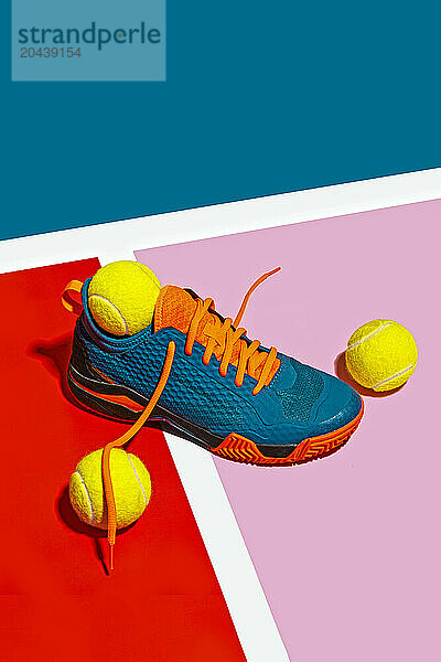 Padle sport shoe and yellow balls on colorful background