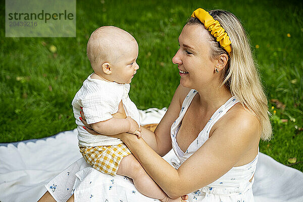 Mother with toddler son sitting in garden