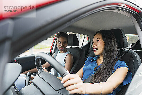 Multiracial women sitting in car