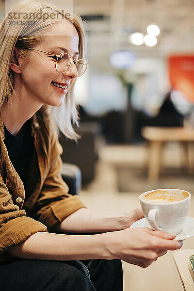 Beautiful woman holding coffee cup at cafe