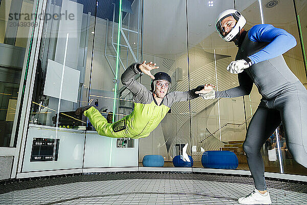 Instructor giving training to participant at indoor skydiving center