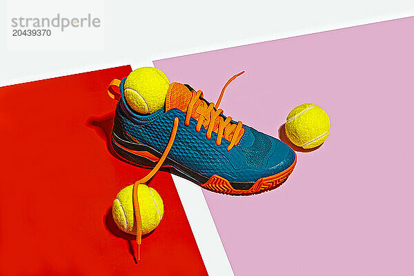 Padle sport shoe and yellow balls over colorful background