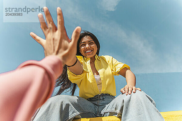 Smiling woman giving high-five to friend